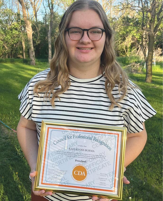 Kali Burma, holding her unofficial certificate until the official one arrives in the mail in a couple of weeks.