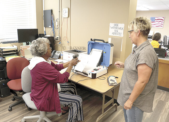 Tracy Legens of McKenzie receives her paper ballot from Mildred Yarbrough at the Election Commission Office.