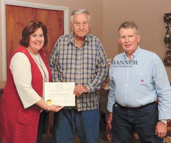 Terry Frazier presents Jerry Dunlap with his high school diploma as Charles Bookout looks on.