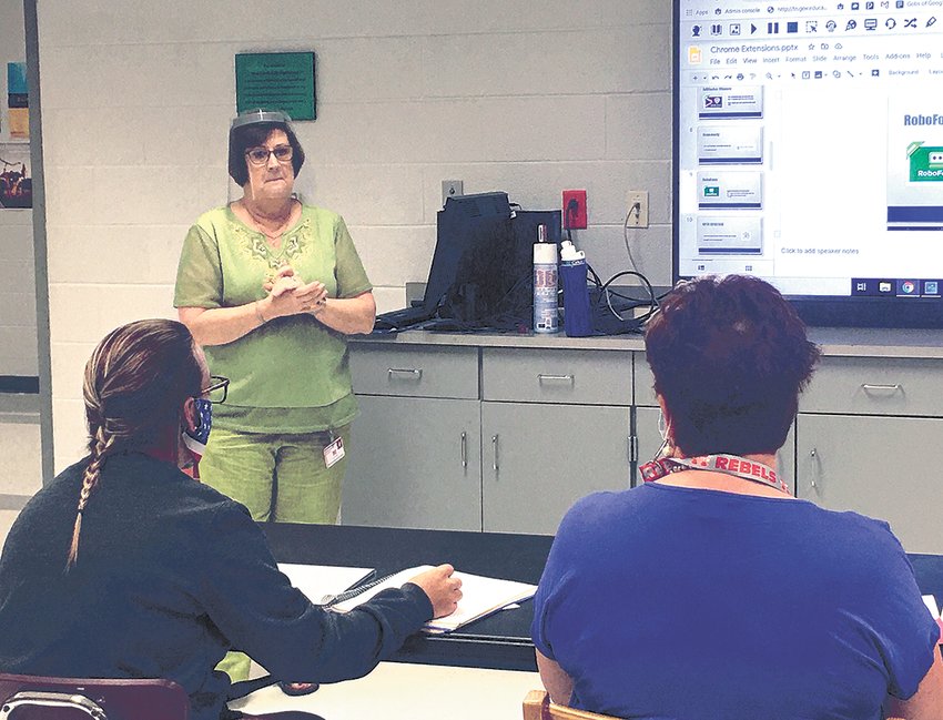 McKenzie schools tech director Dianne Anderson, wearing a face shield, works with educators on the Aristotle K12 Program at a joint McKenzie/West Carroll &ldquo;Tech Day&rdquo; of in-service training at West Carroll Jr./Sr. High School.