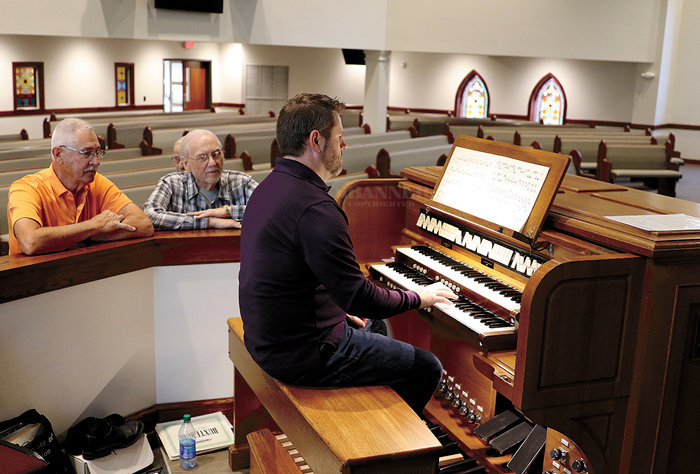 Dr. Keith Herris demonstrates the restored pipe organ at the First Cumberland Presbyterian Church. Rotary members, Ed Dillon and Ed Perkins look on.