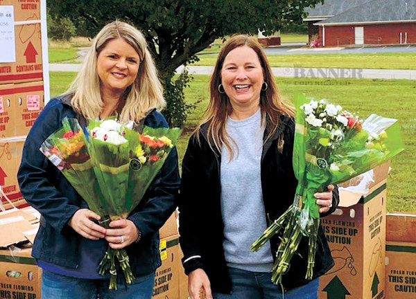 ALL SMILES &mdash; CEO/President of Centennial Bank Andrea Browning, on right, and Angie Wilson hand out bouquets of donated flowers during the Second Harvest Mobile Pantry held May 7.