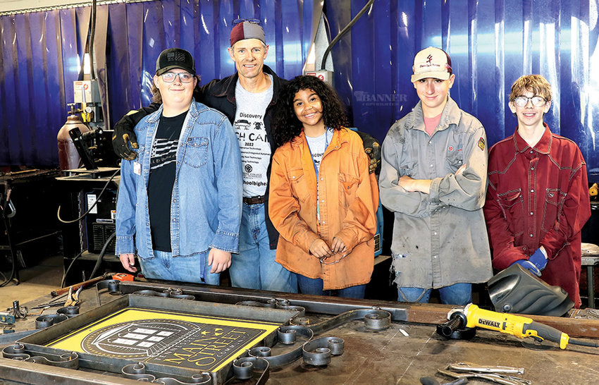 Joe Stallion, Lydia Sumrok, Kellen Finley, and Branson Baker learned to bend and cut metal with David Earley&rsquo;s instruction. Over the course of the week, students bent metal to build a frame (pictured) around a sign for the City of McKenzie.