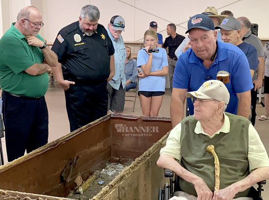 Brad Hurley, president of the Carroll County Chamber of Commerce, Sheriff Andy Dickson and others look into a gooey mess in the time capsule. Huntingdon Mayor Dale Kelley is pictured as he moves past.