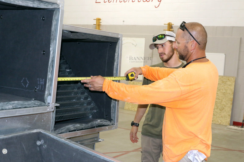 Alan Brasher and Will McBride measure the 26-inch by 26-inch air ducts.