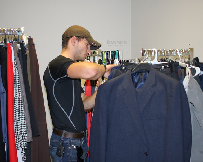 Ethan Carnell, an associate of Cachengo, looks through the men&rsquo;s clothes at Cachengo Closet in McKenzie.