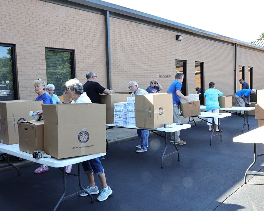 Volunteers at McKenzie Church of Christ package small boxes into shipping boxes for transport to children in third-world countries.