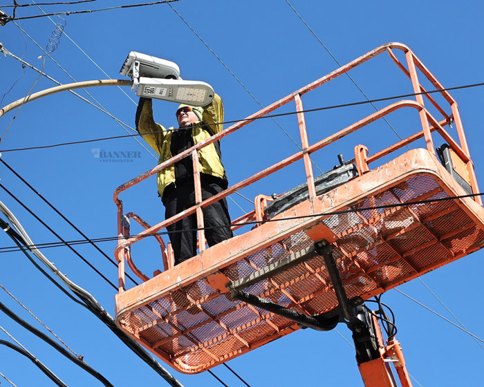 Jason Darnall with Mobile Communications America installs an internet node atop one of the LED street lights adjacent at the intersection of Banner Row and Main Street.