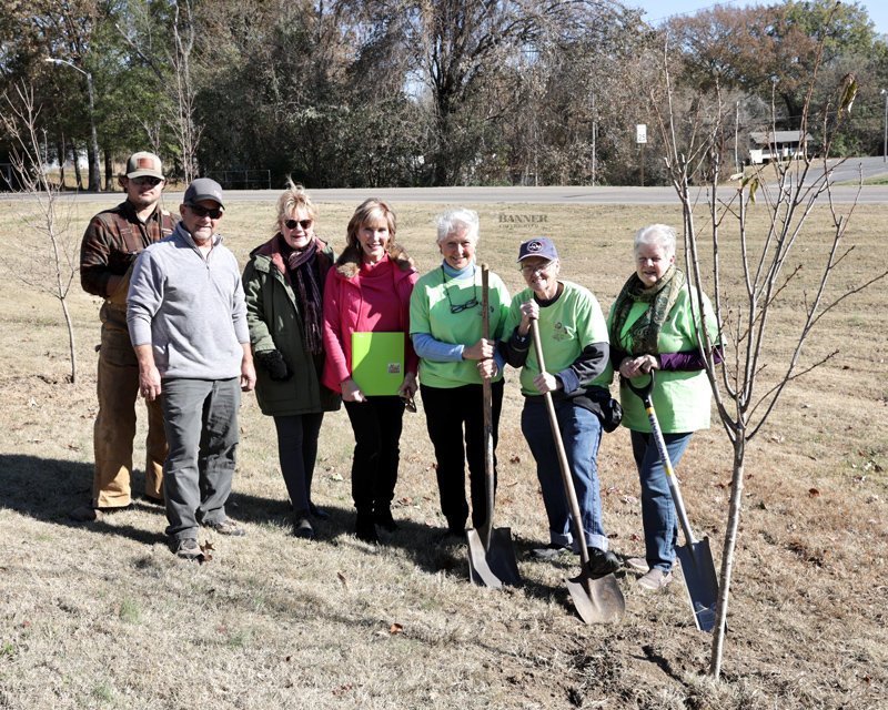 Ethan Travis and Billy Hollowell of the McKenzie Parks Department, Carol Morrissett, Mayor Jill Holland, Judy Davis, Judith Winters and Donna Hodge stand beside a cherry tree planted in honor of Mayor Holland.