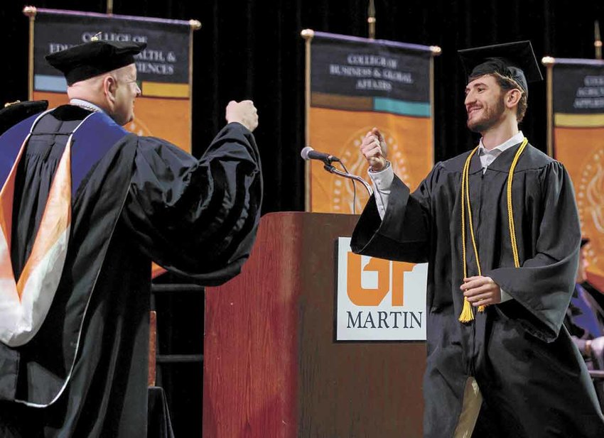 UT-Martin Chancellor Keith Carver gives Will McBride as fist bump as McBride receives his diploma.
