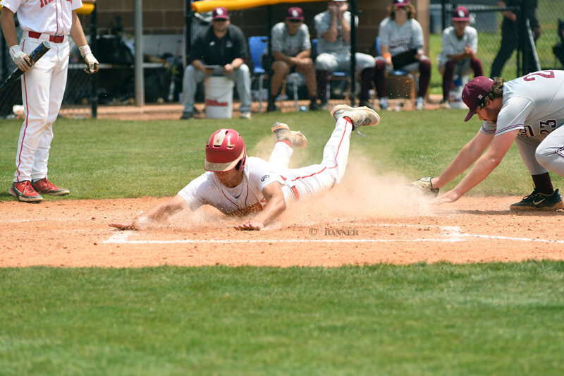 Tate Surber slides into home plate.