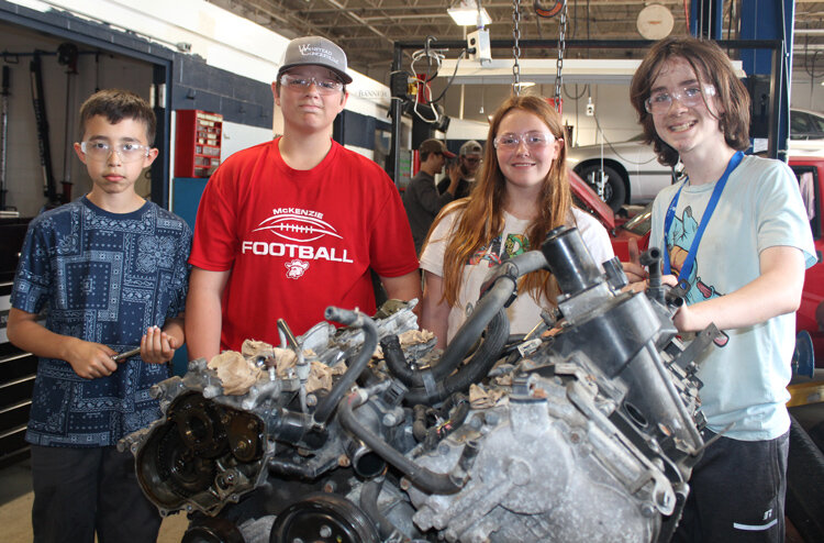 McKenzie students Matthew Ochoa, Hunter Winstead, Janyla Piro and Bryson Smith removed the engine from an Infinity SUV.