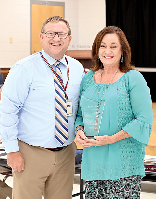 HAPPY RETIREMENT &mdash; West Carroll Superintendent Preston Caldwell presents Mrs. Debbie Reed with a plaque honoring her retirement after 21 years of teaching in the school district. Reed said that she enjoyed all her years of teaching at West Carroll.