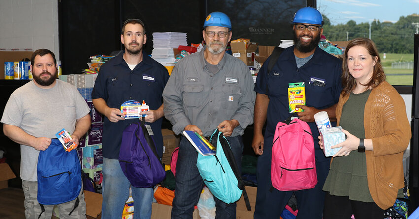 McKenzie Valve &amp; Machining employees Michael Trevathan, Nick Allen, Rick Nash, Chris Gibbs, and Kelsey Little are pictured with some of the donated school supplies. Over the summer, the industry gathered about 160 backpacks full of supplies.