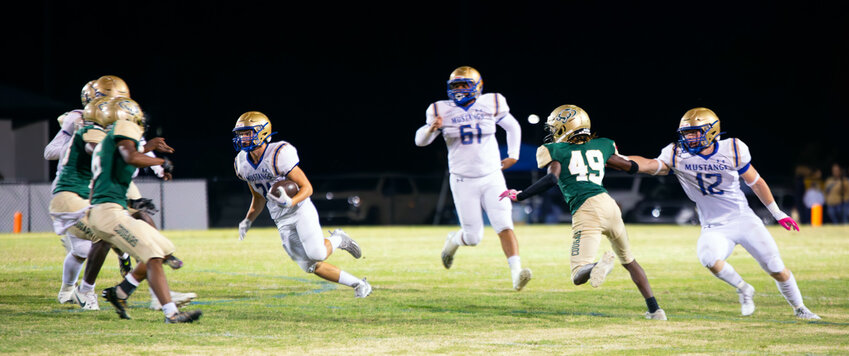 Mustang Brady Warbritton breaks through the Cougar defense for one of his two touchdown runs of the night.