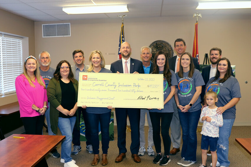 Board members of Carroll County Inclusion Park and local government officials pose for a photo with Commissioner Brad Turner in the check presentation of $497,250. (L to R) Jennifer Johnson, Jimmy Crossett, Allison Williams, State Representative Dr. Brock Martin, Lori Dillahunty, Commissioner Brad Turner, State Senator John Stevens, Krystal Tippitt, Dr Jonathan Kee, Wendy Jones, Carroll County Mayor Joseph Butler, Lincoln Cunningham and Nikki Cunningham.