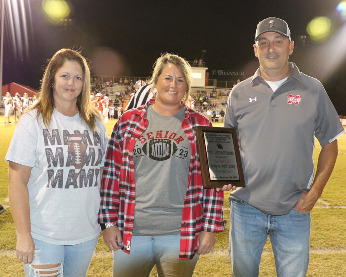 Angela and George Cassidy receive a plaque from Lisa Stewart.