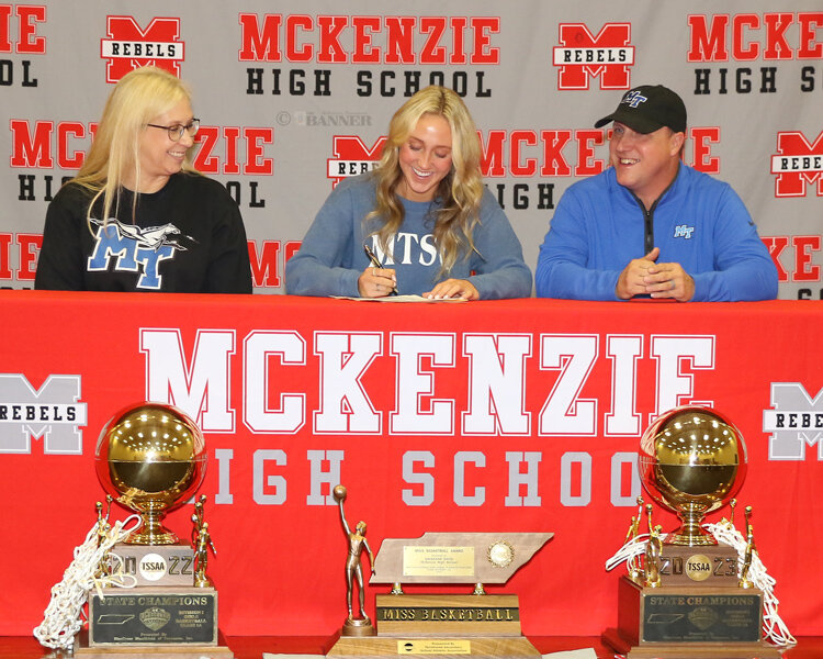 MHS Senior Savannah Davis signs commitment documents to play for MTSU as her parents, Andrea and Boo look on.