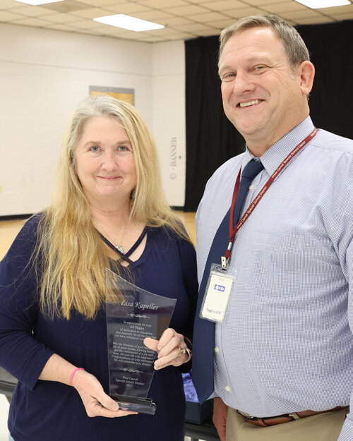 Preston Caldwell, director of schools, presents Lisa Kapeller with a token of appreciation for her service as a school nurse for 24 years. Kapeller is retiring.