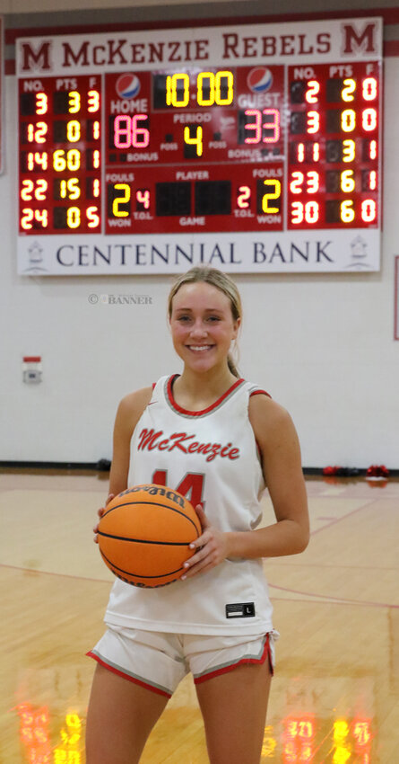 Savannah Davis holds the game ball following the 86-33 victory over Milan. The scoreboard illuminates the final score and Davis&rsquo; 60-point game, which tied the existing record held by Anna Comer.