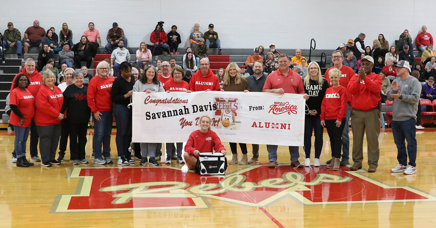 Savannah Davis sits in front of a vinyl banner honoring her for breaking a TSSAA record. She was honored by MHS Alumni Association and Pepsi Mid-America.