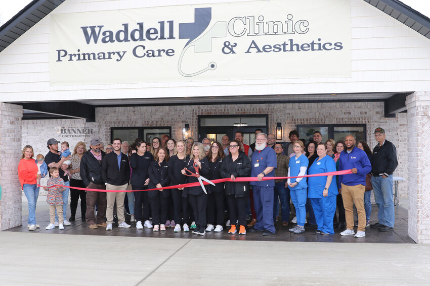 Waddell Clinic Primary Care and Aesthetics held its grand opening on March 15 in Henry. Donna Waddell cuts the ribbon as associates, friends and family look on.