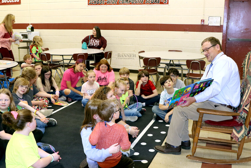 Preston Caldwell, director of schools, reads to the elementary-aged children during &lsquo;Let&rsquo;s Glow Read.&rsquo;