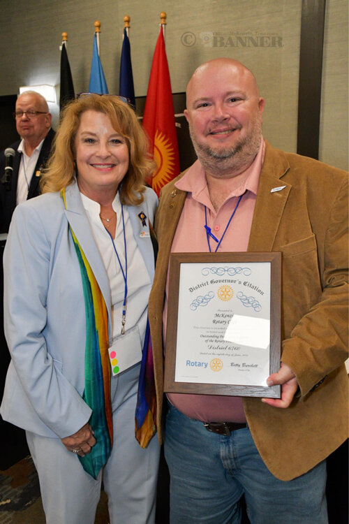 McKenzie Rotary President Jason R. Martin (right) is presented a certificate by District Governor Betty Burchett (right).