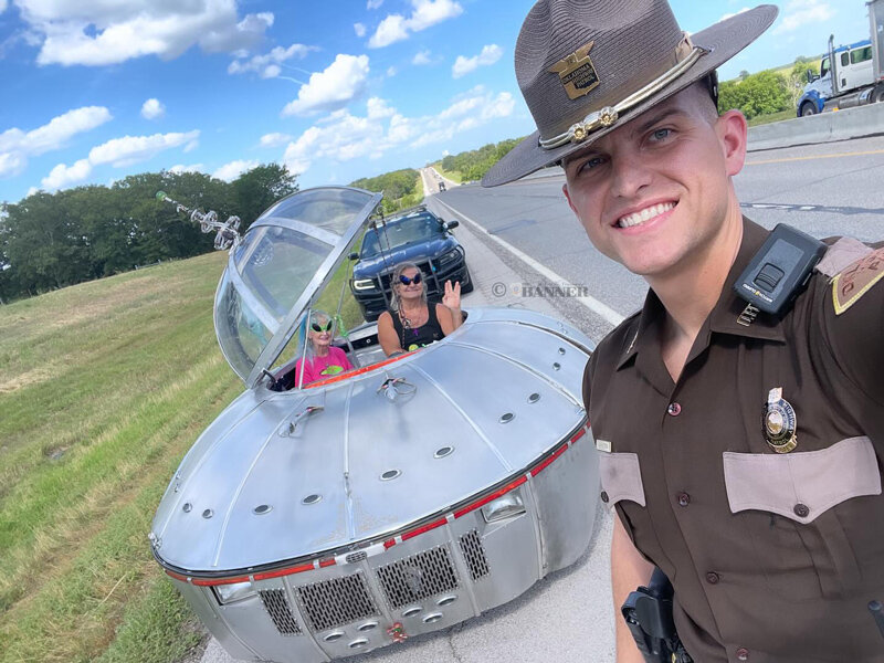 An Oklahoma trooper poses with the UFO vehicle.