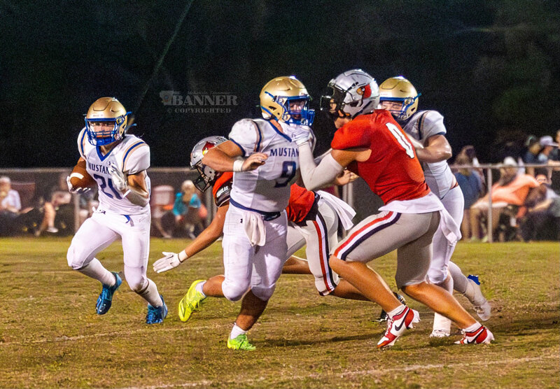 Huntingdon&rsquo;s Brady Warbritton #21 rounds the corner for positive yards as Gray Eubanks #9 blocks the edge.