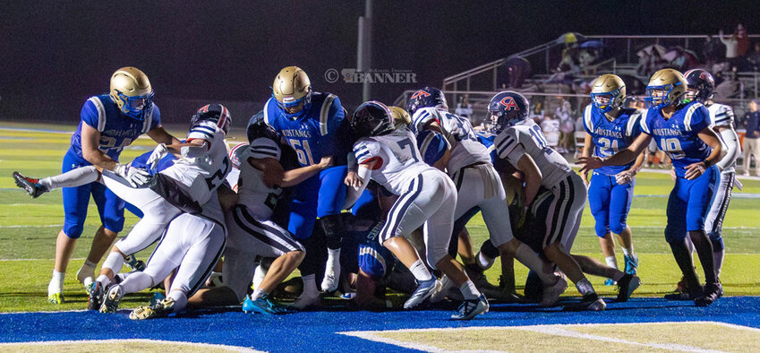 Gray Eubanks punches in the Mustang touchdown through a scrum of offensive and defensive linemen.