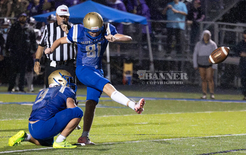 Greyson Anderson kicks the extra point during a down pour.