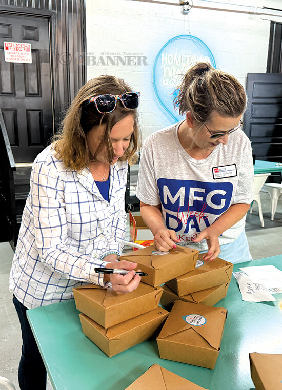 Tessa Kyle and Janna Hellums of TN Economic and Community Development help pack lunches for the McKenzie manufacturing plants.