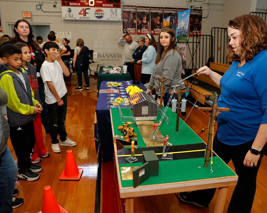 Carroll County Electrical Department had a miniature display about safety around electrical utilities. Kelly Fields, office manager, demonstrates to students how electricity can arc and create a hazard if a person does not exercise proper safety.