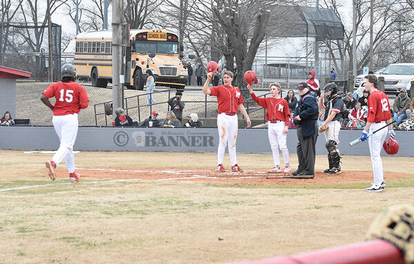 Rebel KD Cunningham trots home on a three-run home run in the first inning, awaited at the plate by teammates Craegen Travis and Cooper Davidson.