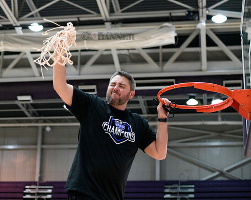 Lady Wildcat Coach Chris Nelson celebrates the conference championship win by cutting down the net.