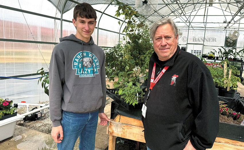 Kellen Finley, a McKenzie High School FFA student, sells live plants to Kevan King, a computer tech at the school.