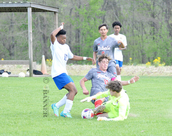 Rebel Skyler Fornera and Mustang goalkeeper Gage Foster collide making a play on the ball.