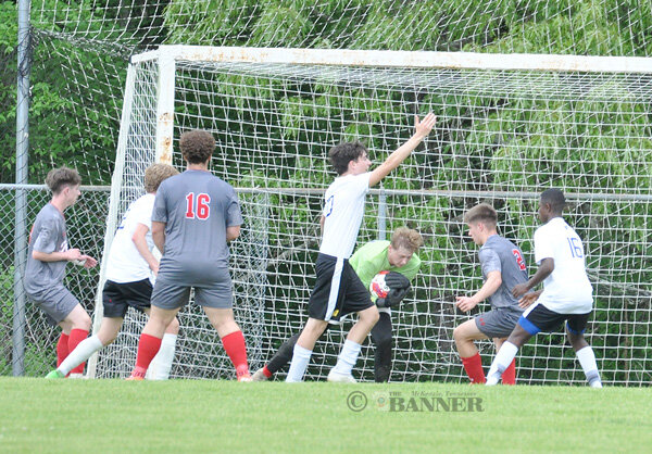 Rebel goalkeeper Nate Dameron secures the ball with a crowd at the goal for one of his seven saves.