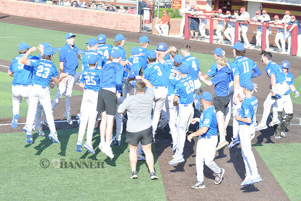 The Mustangs swarm Braylon Rich at home plate after his three-run home run in the second game of the day.