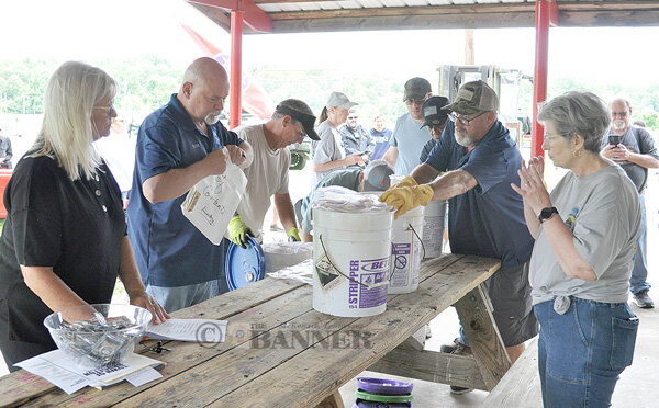 Mayor Robert Keeton III, City Recorder Annie Hand and others distribute the approximately 60 sealed bags of items contributed by families, individuals and civic organizations to those present.