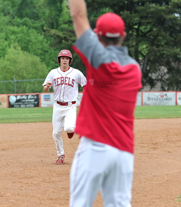 Coach Wall Signals a runner to round 3rd base.
