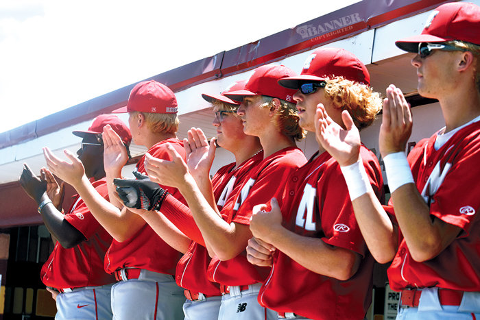 Rebel teammates cheer from the dugout.