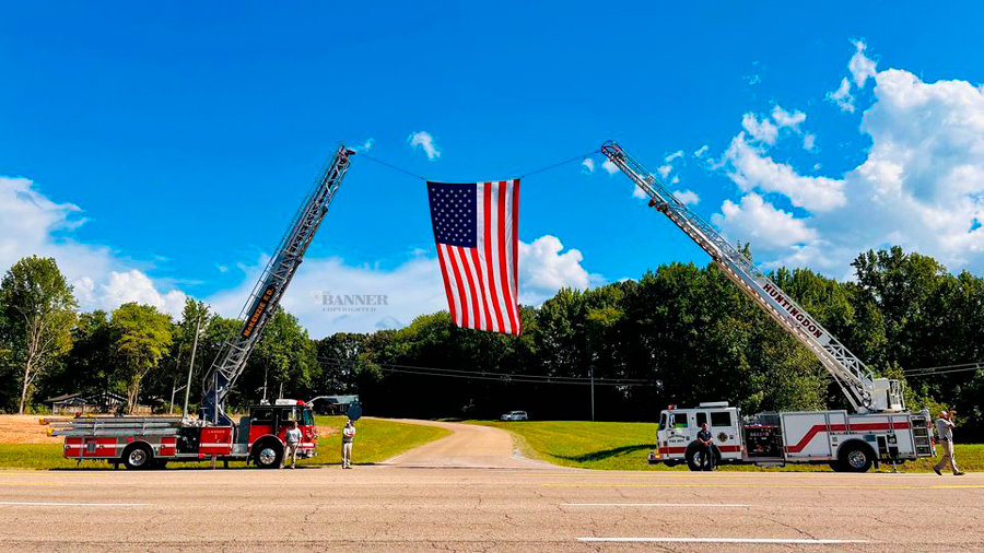 McKenzie Fire Department and Huntingdon Fire Department hoist a giant American flag between their ladder trucks.