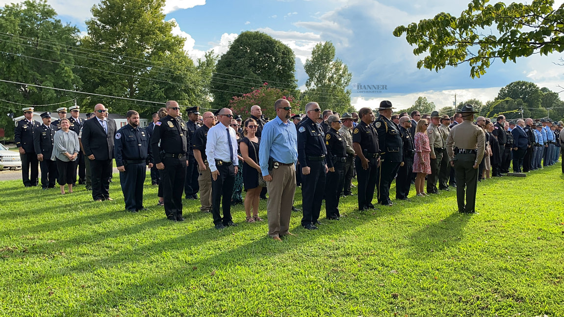 Law enforcement and first responders from throughout the United States stand in formation as a sign of respect.
