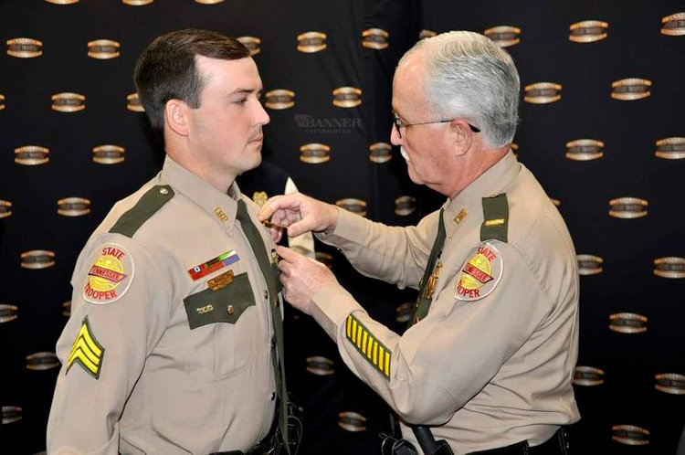 Lieutenant Steve Russell (right) pins sergeant stripes on his son, Lee Russell.