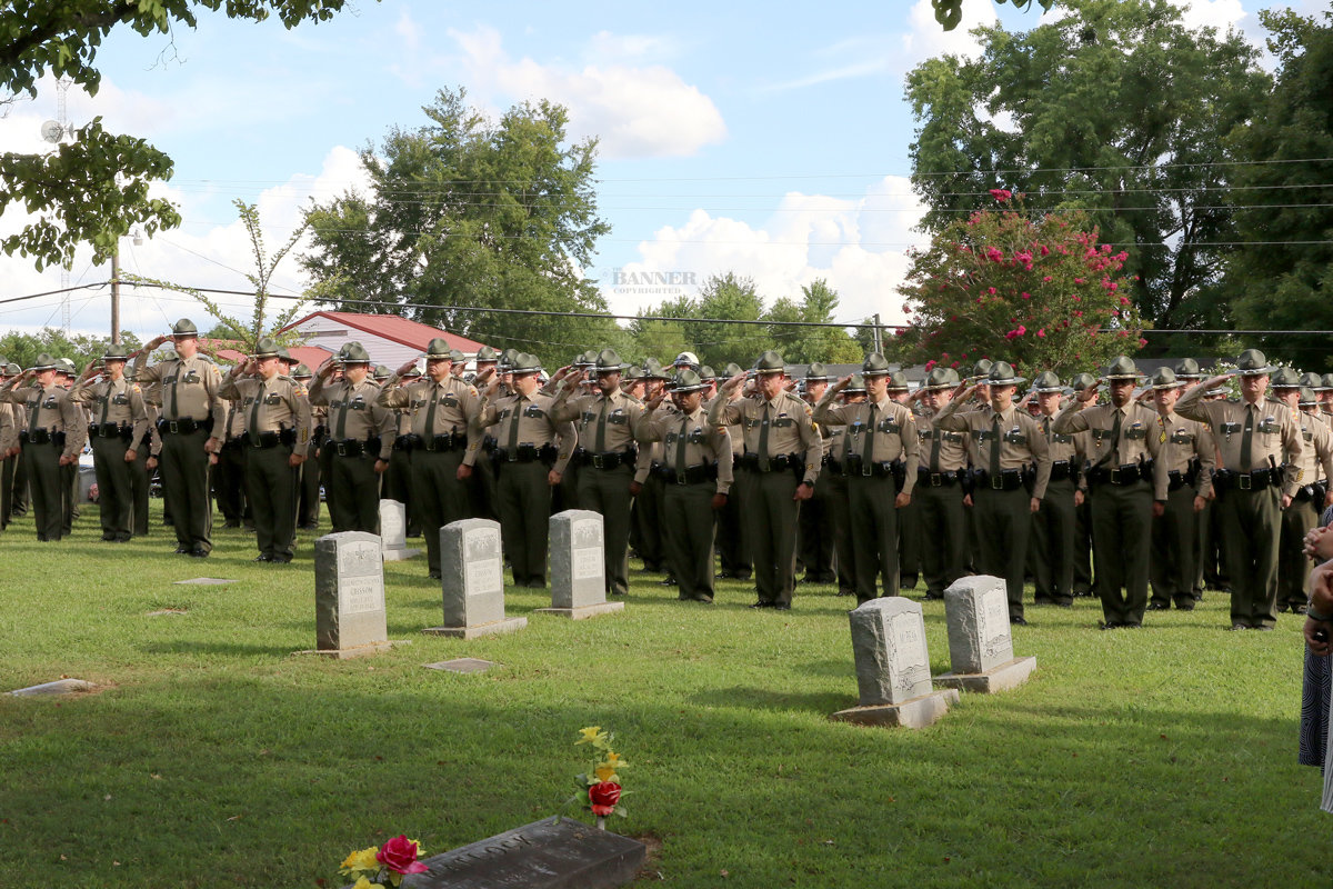 Tennessee Highway Patrol officers salute during the graveside services.