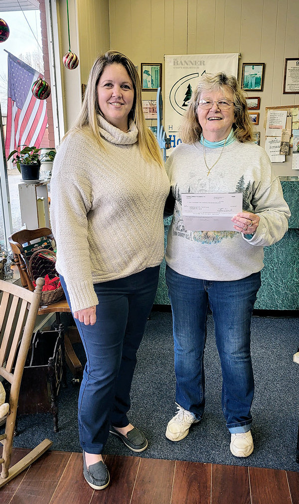 Lisa Stewart from McKenzie Banking Company presents Becky Burkhalter, office manager of the Carroll County Habitat for Humanity, a check for $2500 from the Charles P. Wilson Foundation.