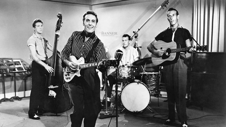 Carl Perkins (center) with his band. Perkins wrote and recorded Blue Suede Shoes for Sun Records, their first million copy seller.