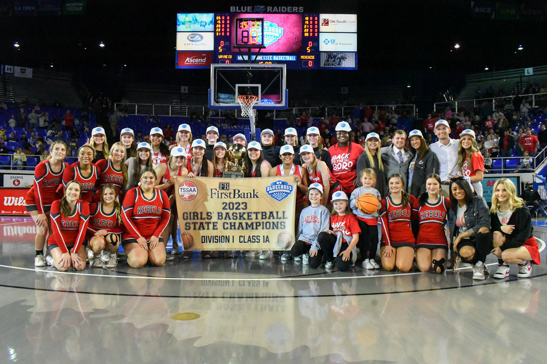McKenzie Lady Rebels Basketball team proudly displays the Gold Ball surrounded by cheerleaders, coaches and managers.